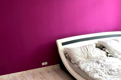 Kleines Modernes Hauptschlafzimmer mit lila Wandfarbe, Laminat und grauem Boden in Sonstige
