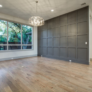 This is an example of a large modern home studio in Dallas with beige walls, light hardwood flooring and no fireplace.