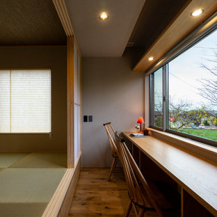 他の地域の小さいモダンスタイルのおしゃれなホームオフィス・仕事部屋 (グレーの壁、無垢フローリング、造り付け机、茶色い床) の写真