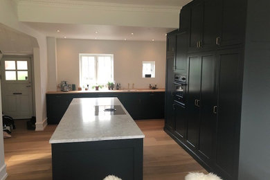 This is an example of an expansive traditional open plan kitchen in Aarhus with raised-panel cabinets, grey cabinets and with island.