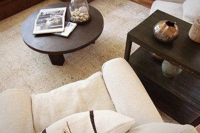 Example of a mid-sized country open concept medium tone wood floor living room design in San Luis Obispo with white walls, a standard fireplace, a stone fireplace and no tv