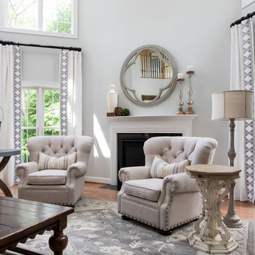 Neutral Two Story Family Room with Tufted Wing Chairs
