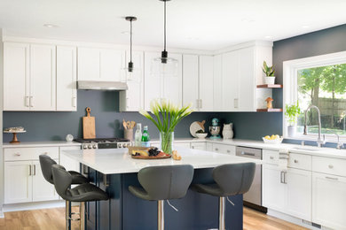 Inspiration for a large transitional l-shaped vinyl floor eat-in kitchen remodel in Minneapolis with an undermount sink, shaker cabinets, white cabinets, quartz countertops, stainless steel appliances, an island and white countertops