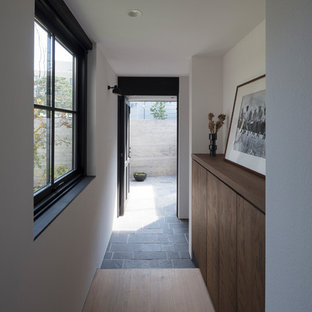 東京23区の片開きドアラスティックスタイルのおしゃれな玄関 (白い壁、黒いドア) の写真