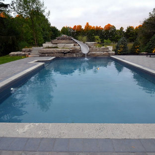Mittelgroßes Klassisches Sportbecken hinter dem Haus in rechteckiger Form mit Wasserrutsche und Pflasterklinker in Toronto
