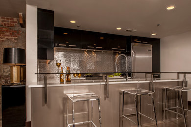 Mid-sized trendy l-shaped vinyl floor eat-in kitchen photo in New Orleans with an undermount sink, flat-panel cabinets, black cabinets, quartz countertops, metallic backsplash, metal backsplash, stainless steel appliances and a peninsula