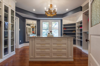 Inspiration for a mid-sized transitional gender-neutral walk-in wardrobe in New York with shaker cabinets, white cabinets and medium hardwood floors.