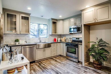 Inspiration for a mid-sized modern l-shaped laminate floor and gray floor enclosed kitchen remodel in Chicago with a farmhouse sink, beaded inset cabinets, beige cabinets, quartz countertops, gray backsplash, ceramic backsplash, stainless steel appliances, no island and gray countertops