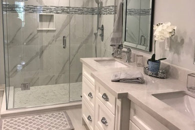 This is an example of a large traditional master bathroom in Toronto with furniture-like cabinets, white cabinets, a double shower, a one-piece toilet, white tile, porcelain tile, blue walls, porcelain floors, an undermount sink, engineered quartz benchtops, white floor, a hinged shower door and grey benchtops.