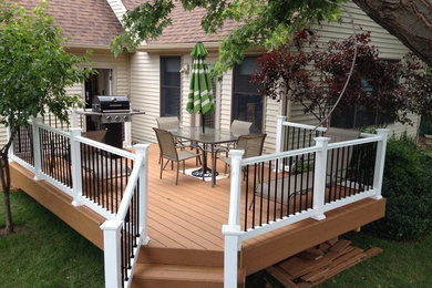 Example of a mid-sized backyard deck design in Other with no cover