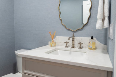 Small elegant powder room photo in New York with shaker cabinets, beige cabinets, a two-piece toilet, blue walls, an undermount sink, quartz countertops, white countertops and a built-in vanity