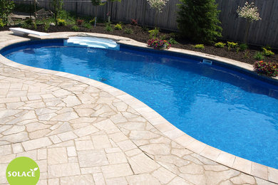 Mid-sized elegant backyard concrete paver and kidney-shaped pool photo in Ottawa