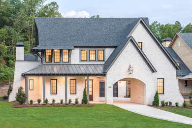 Transitional two-story brick house exterior idea in Other with a shingle roof and a black roof