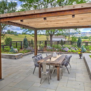 Imagen de patio de estilo de casa de campo, grande, en patio trasero, con pérgola y adoquines de piedra natural
