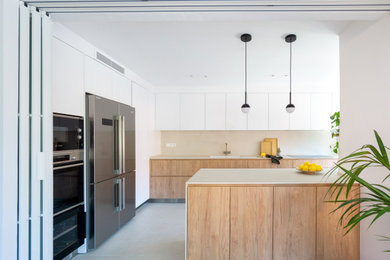 Diseño de cocina comedor actual con fregadero bajoencimera, armarios con paneles lisos, puertas de armario de madera oscura, encimera de esteatita, salpicadero verde, salpicadero de losas de piedra, electrodomésticos de acero inoxidable, suelo de baldosas de cerámica, una isla, suelo multicolor y encimeras grises
