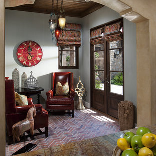 Kleines Mediterranes Wohnzimmer mit Backsteinboden, grauer Wandfarbe und rotem Boden in Phoenix