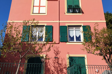 Imagen de fachada de casa rosa tradicional de tamaño medio de tres plantas con tejado a cuatro aguas