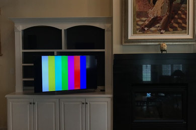Mid-sized trendy open concept medium tone wood floor and beige floor home theater photo in Richmond with beige walls and a wall-mounted tv