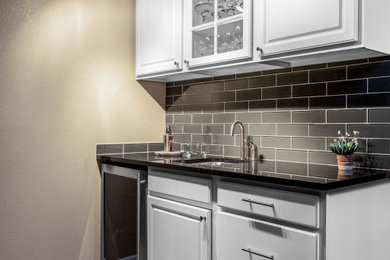 Example of a mid-sized trendy underground laminate floor basement design in Denver with beige walls