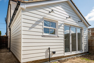 Medium sized beach style semi-detached house in Kent with concrete fibreboard cladding, a pitched roof and board and batten cladding.