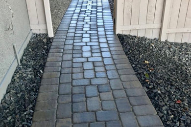 Inspiration for a mid-sized transitional drought-tolerant and partial sun side yard stone walkway in Las Vegas for fall.