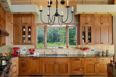 Large transitional l-shaped medium tone wood floor eat-in kitchen photo in Burlington with a double-bowl sink, medium tone wood cabinets, granite countertops, beige backsplash, ceramic backsplash, stainless steel appliances, a peninsula and shaker cabinets