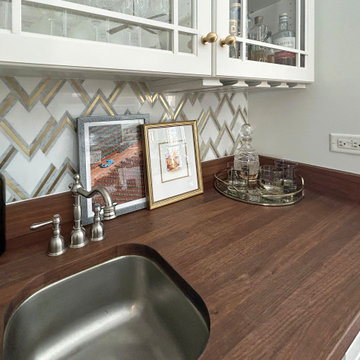 Heritage Reimagined: Chevron Tile Wet Bar with Glass-Front Display Cabinets