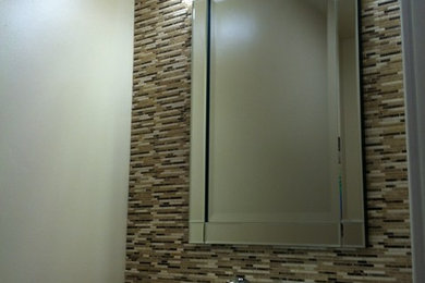Bathroom - contemporary beige tile bathroom idea in Columbus with a vessel sink, flat-panel cabinets, white cabinets, granite countertops and a two-piece toilet