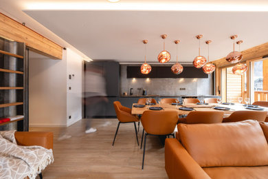 Idée de décoration pour une salle à manger ouverte sur le salon minimaliste en bois de taille moyenne avec un mur gris, parquet clair, aucune cheminée, un sol beige, boiseries et éclairage.