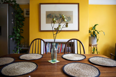 Inspiration for a classic dining room in Wiltshire with yellow walls, medium hardwood flooring and brown floors.