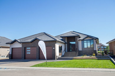 Photo of a mid-sized contemporary one-storey stucco beige exterior in Calgary.