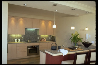 Eat-in kitchen - mid-sized u-shaped porcelain tile eat-in kitchen idea in San Francisco with a double-bowl sink, flat-panel cabinets, light wood cabinets, granite countertops, multicolored backsplash, stone slab backsplash, stainless steel appliances and a peninsula