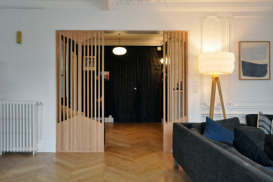 Réalisation d'un grand hall d'entrée design avec un mur blanc et parquet clair.