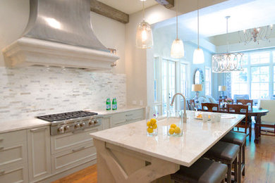 Enclosed kitchen - large transitional u-shaped medium tone wood floor and brown floor enclosed kitchen idea in Atlanta with an undermount sink, recessed-panel cabinets, light wood cabinets, quartzite countertops, white backsplash, stone tile backsplash, paneled appliances, an island and white countertops