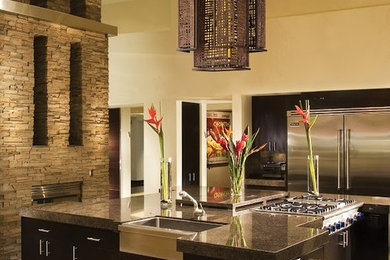 Open concept kitchen - mid-sized contemporary l-shaped travertine floor and brown floor open concept kitchen idea in Denver with a farmhouse sink, flat-panel cabinets, dark wood cabinets, granite countertops, stainless steel appliances and an island