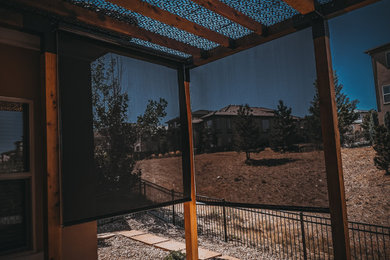 Example of a large minimalist backyard stamped concrete patio design in Denver with a pergola