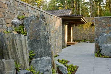 Photo of a contemporary shade front yard stone landscaping in Seattle.