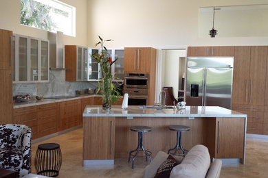 Inspiration for a contemporary l-shaped eat-in kitchen remodel in Miami with an undermount sink, flat-panel cabinets, medium tone wood cabinets, quartzite countertops, gray backsplash, stone slab backsplash and stainless steel appliances