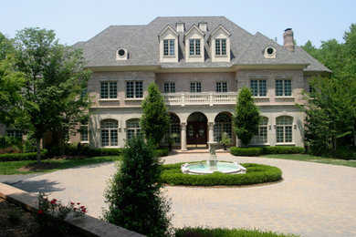 Huge beige three-story brick exterior home idea in DC Metro
