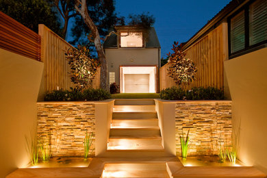 Modern backyard garden in Sydney with a water feature and natural stone pavers.