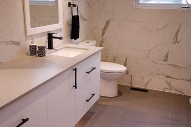 Bathroom - mid-sized contemporary kids' black and white tile and porcelain tile porcelain tile, gray floor and single-sink bathroom idea in Ottawa with flat-panel cabinets, white cabinets, a one-piece toilet, white walls, an undermount sink, quartz countertops, gray countertops and a floating vanity