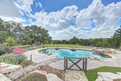 Large cottage backyard stone and kidney-shaped natural hot tub photo in Austin