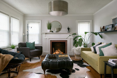 Mid-sized 1960s enclosed medium tone wood floor living room photo in Other with gray walls, a standard fireplace and a brick fireplace