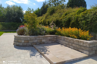 Mittelgroßer, Halbschattiger Mediterraner Garten im Sommer, neben dem Haus mit Hochbeet und Natursteinplatten in Nürnberg