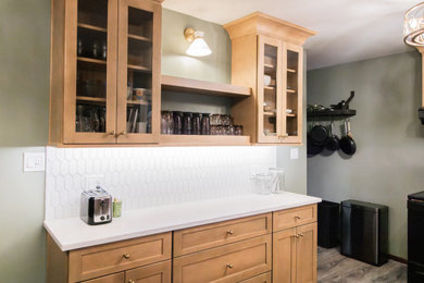 Small transitional u-shaped dark wood floor and brown floor dry bar photo in Philadelphia with an undermount sink, glass-front cabinets, medium tone wood cabinets, quartz countertops, white backsplash, stone tile backsplash and white countertops
