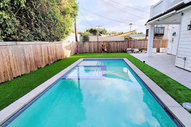 Ejemplo de piscinas y jacuzzis alargados minimalistas de tamaño medio rectangulares en patio trasero con suelo de baldosas