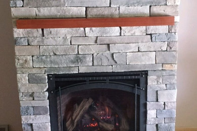 Example of a mid-sized classic family room design in New York with a standard fireplace and a stone fireplace