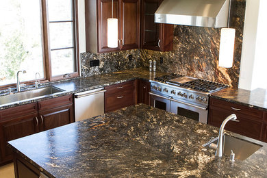 Inspiration for a timeless enclosed kitchen remodel in Santa Barbara with an undermount sink, dark wood cabinets, granite countertops, stone slab backsplash, stainless steel appliances and an island