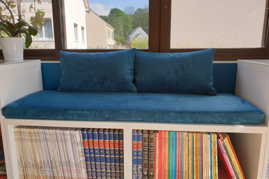 Inspiration pour un salon design avec une bibliothèque ou un coin lecture et un mur bleu.