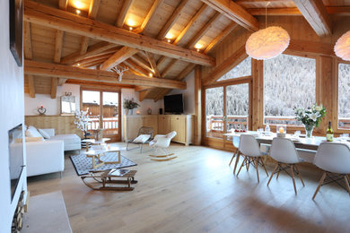 Imagen de salón abierto y blanco y madera rústico grande con paredes blancas, suelo de madera clara, vigas vistas y madera